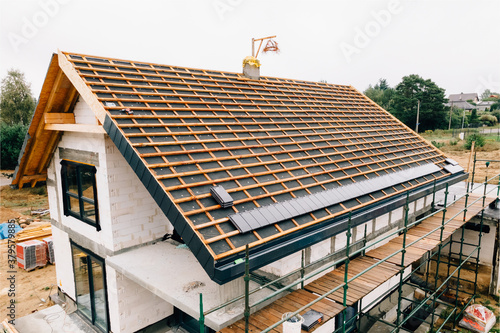 laying tiles on the roof of a single-family house © Filip Olejowski