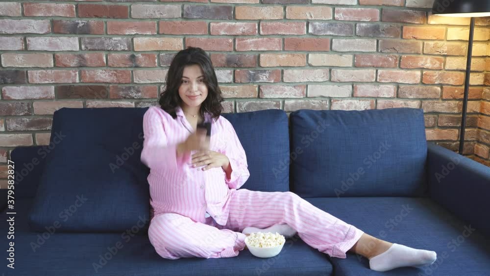 Adorable pregnant female enjoy watching tv at home, caucasian woman expect baby, sit on sofa in domestic wear alone. Adorable pregnant female enjoy watching tv at home, caucasian woman expect baby, sit on sofa in domestic wear alone.