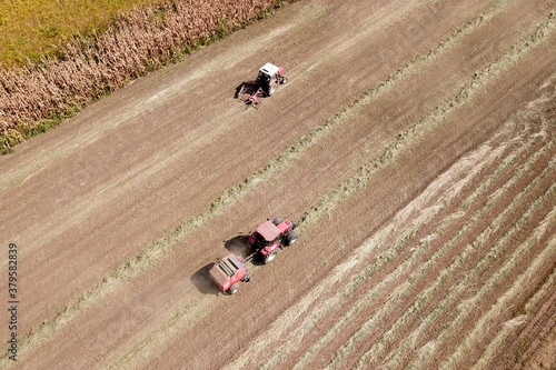 Top view of two red Tractor baling hay