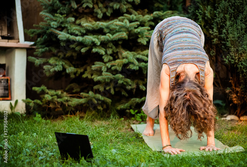 woman doing yoga in green backyard