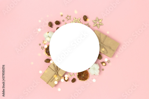 Round clean mockup with frame made of Christmas decoration and gift boxes on a pink background. Holidays concept with copy space. © rorygezfresh