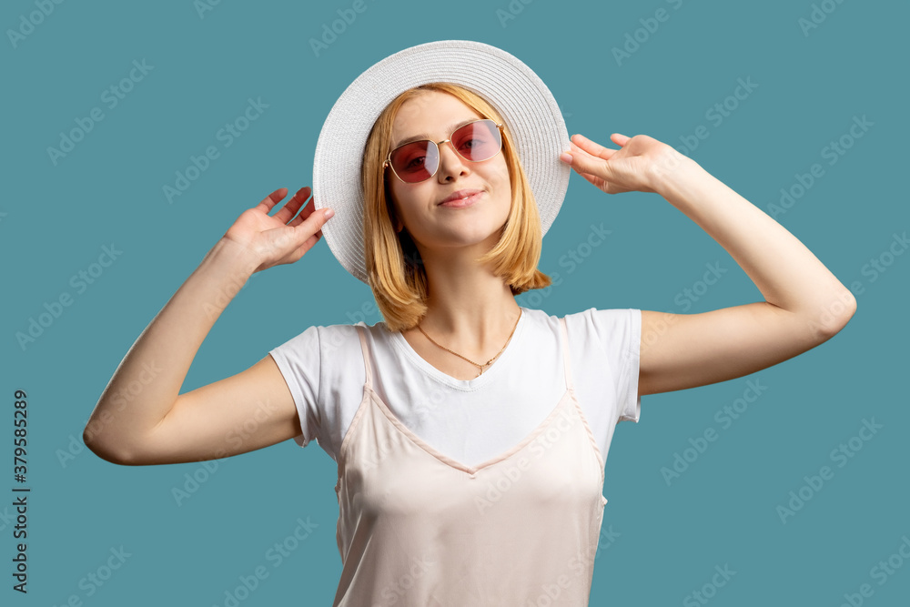 Holiday accessories. Summer trip. Happy woman in white outfit gypsy hat and sunglasses enjoying vacation isolated on blue. Travel agency. Trendy headwear. Sun protection Holiday accessories. Summer trip. Happy woman in white outfit gypsy hat and sunglasses enjoying vacation isolated on blue. Travel agency. Trendy headwear. Sun protection