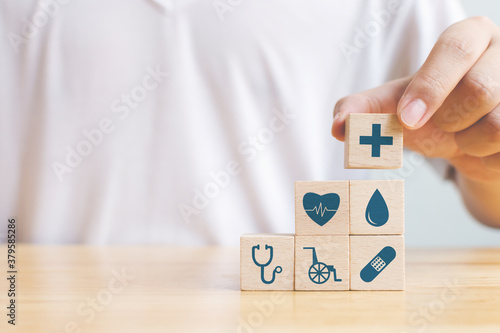 Hand arranging wood block stacking with icon healthcare medical, Insurance for your health concept photo