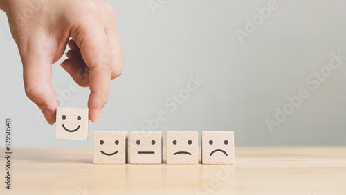 Hand choose wooden cube block with icon face smile, The best excellent business services rating customer experience, Satisfaction survey concept