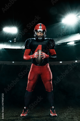 American football player, athlete sportsman in red helmet on stadium background. Sport and motivation wallpaper. © Mike Orlov