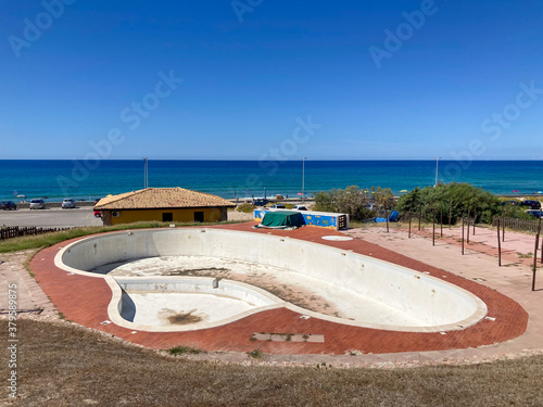 Una piscina abbandonata presso la spiaggia Li Junchi di Badesi, Sassari, Sardegna photo
