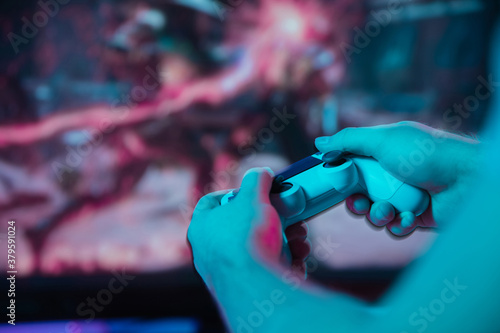 Foto Back view close up of professional gamer playing online video game with his gameset