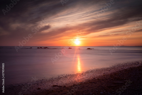 Sunset on the rocks at a very high tide on Sker Beach near Porthcawl, South Wales UK
