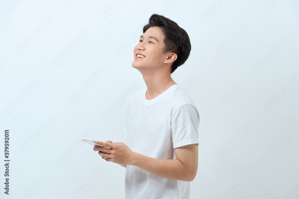 Smiling young good looking Asian man using smartphone Smiling young good looking Asian man using smartphone