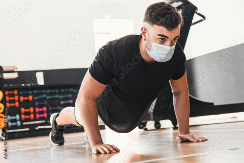 boy doing push-ups while wears a mask