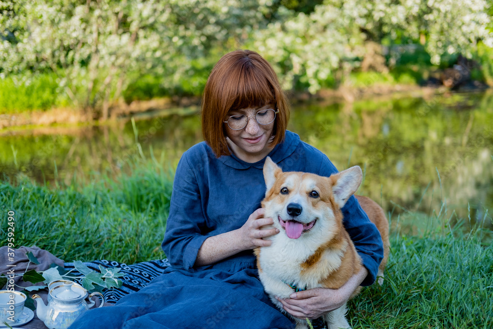 Φωτογραφία Young woman in retro dress with funny corgi dog on the picnic, female with cute