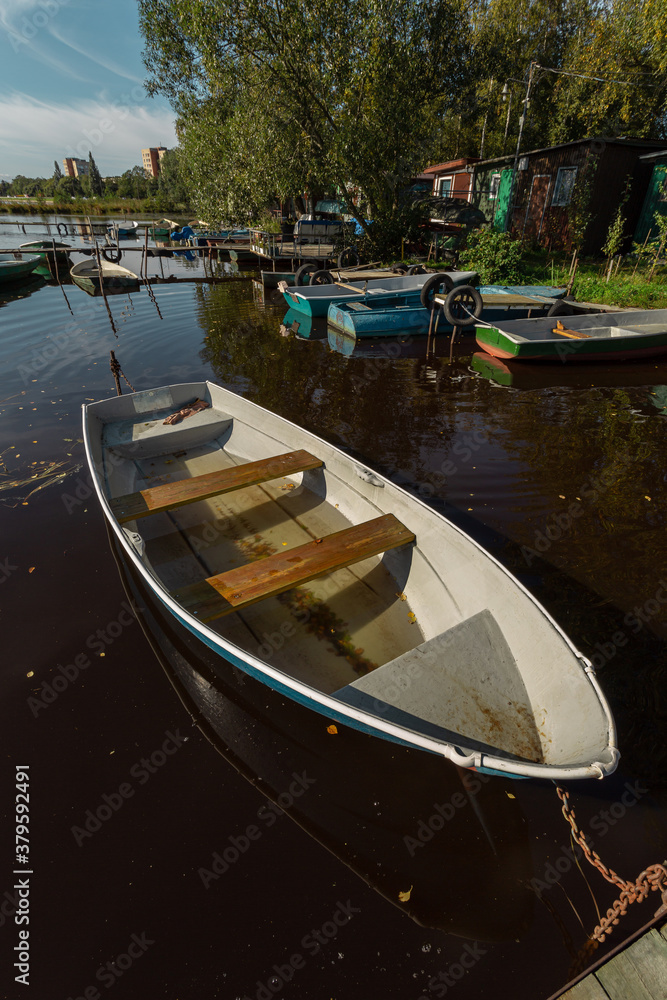 Lone wooden fishing  boat at rest in a floating village by the big city of Sestroretsk, Russia.