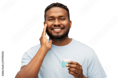 grooming, skin care and people concept - happy african american man applying wax to his beard over white background