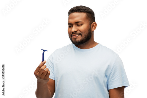beard shaving, grooming and people concept - african american man with manual razor blade over white background