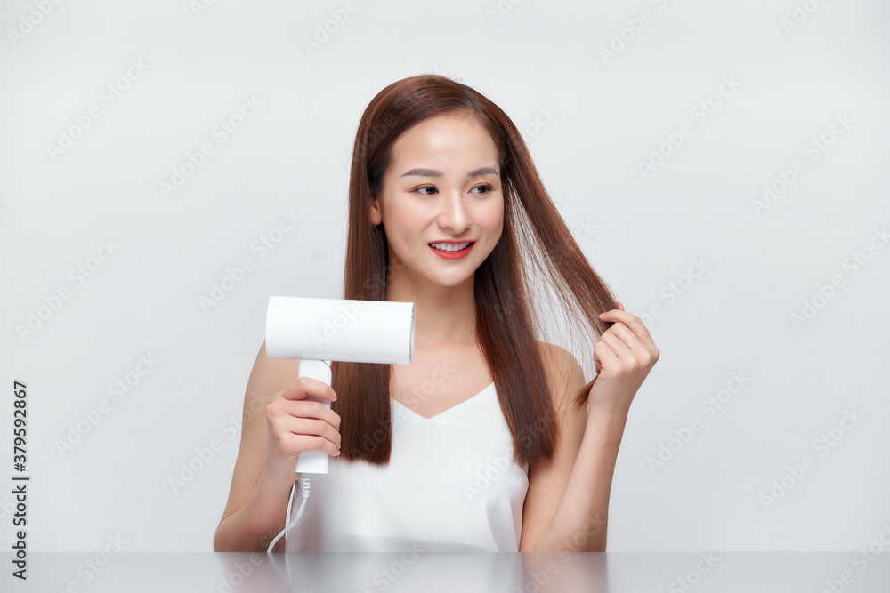 Beautiful Smiling Woman Drying Healthy Long Straight Hair Using Hair Dryer. Beautiful Smiling Woman Drying Healthy Long Straight Hair Using Hair Dryer.