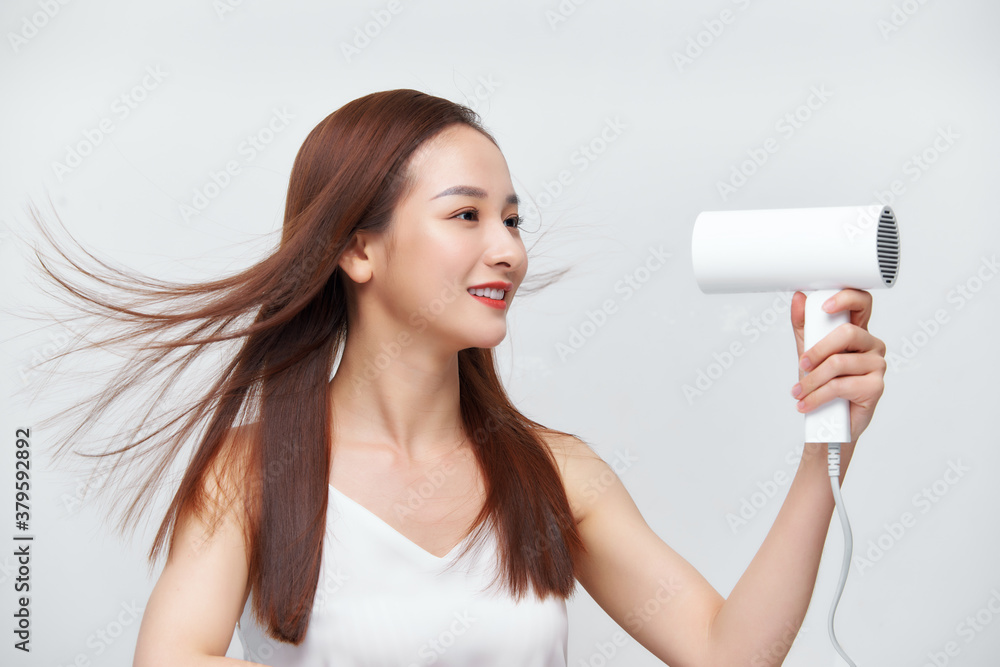 Funny girl drying her freshly washed hair looking in the mirror Funny girl drying her freshly washed hair looking in the mirror