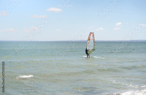 Recreational Water Sports. Windsurfing. Windsurfer Surfing The Wind On Waves In Ocean, Sea. Extreme Sport Action. Recreational Sporting Activity. Healthy Active Lifestyle. soft focus photo