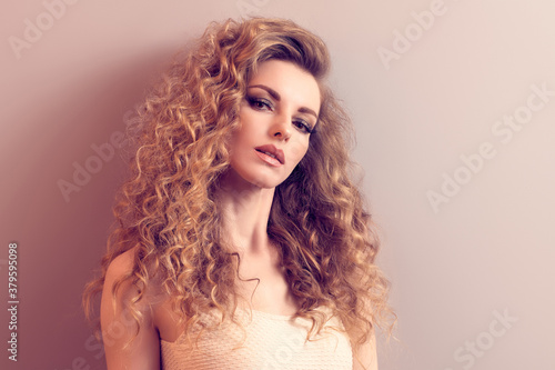 Beauty fashion woman portrait. Gorgeous young blonde with long curly hair healthy skin, makeup. Beautiful female face. Smiling model girl, fashionable hairstyle. Skincare make up concept