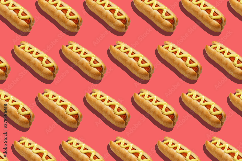 Fast food for company. Appetizing hot dogs with sausage and mustard on pink background Fast food for company. Appetizing hot dogs with sausage and mustard on pink background