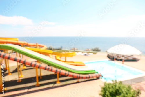 Different colorful slides in water park, blurred view © New Africa