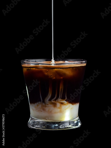 Cafe bombon tipico de españa sobre fondo negro con leche condensada