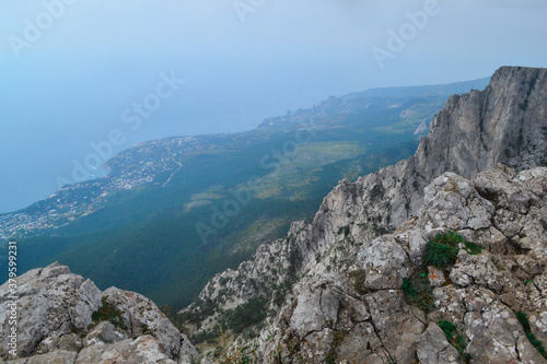 Abyss in steep rocks Ai-Petri, Crimea. Cliff against the backdrop of blue coastline with city and forest, beautiful summer landscape © SymbiosisArtmedia