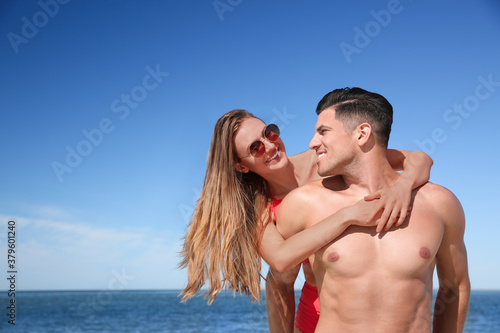 Beautiful woman and her boyfriend on beach. Happy couple
