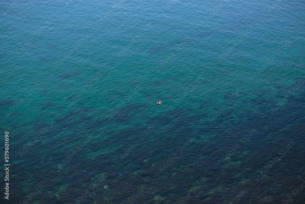 the sea surface with a man in the distance