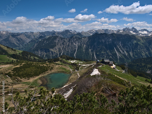 Beautiful panorama view from the top of alpine Fellhorn peak (2,037 m) near Oberstdorf, Allgäu, Bavaria, Germany with mountain station of Fellhornbahn and turquoise shimmering Schlappolt Lake.