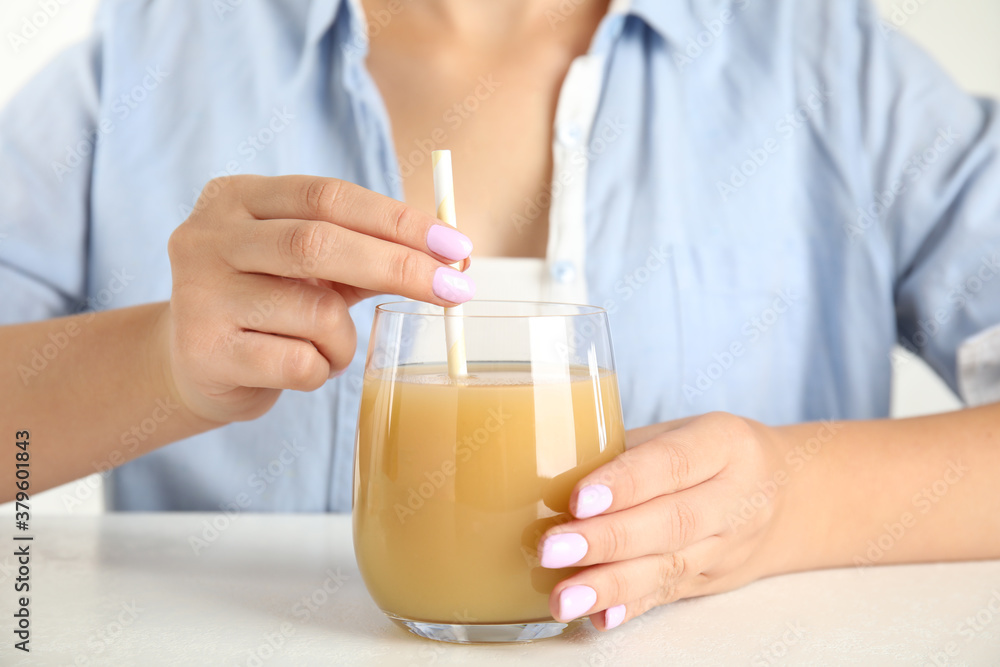 Woman with tasty pear juice at white table, closeup Woman with tasty pear juice at white table, closeup
