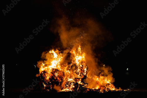 Hot red burning large fire with the black starry night sky.