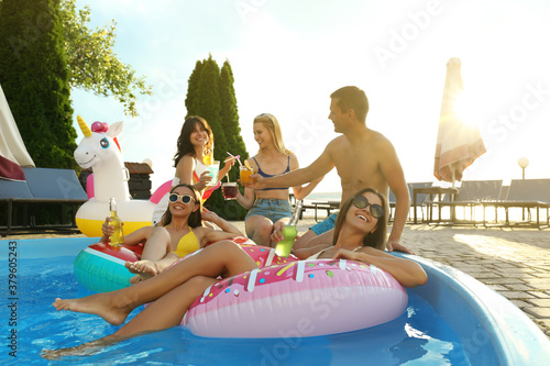 Group of happy people with refreshing drinks enjoying fun pool party © New Africa