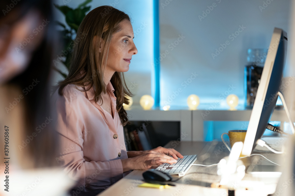 Concentrated mature business woman working with her computer in the office. Concentrated mature business woman working with her computer in the office.