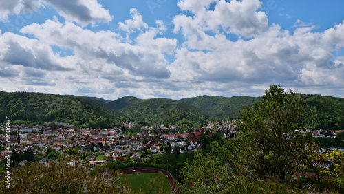 Panorama view over village Dahn (Palatinate Forest, Rhineland-Palatinate, Germany), located in a valley surrounded by forests and hills with sandstone formation in background at sunny spring day.