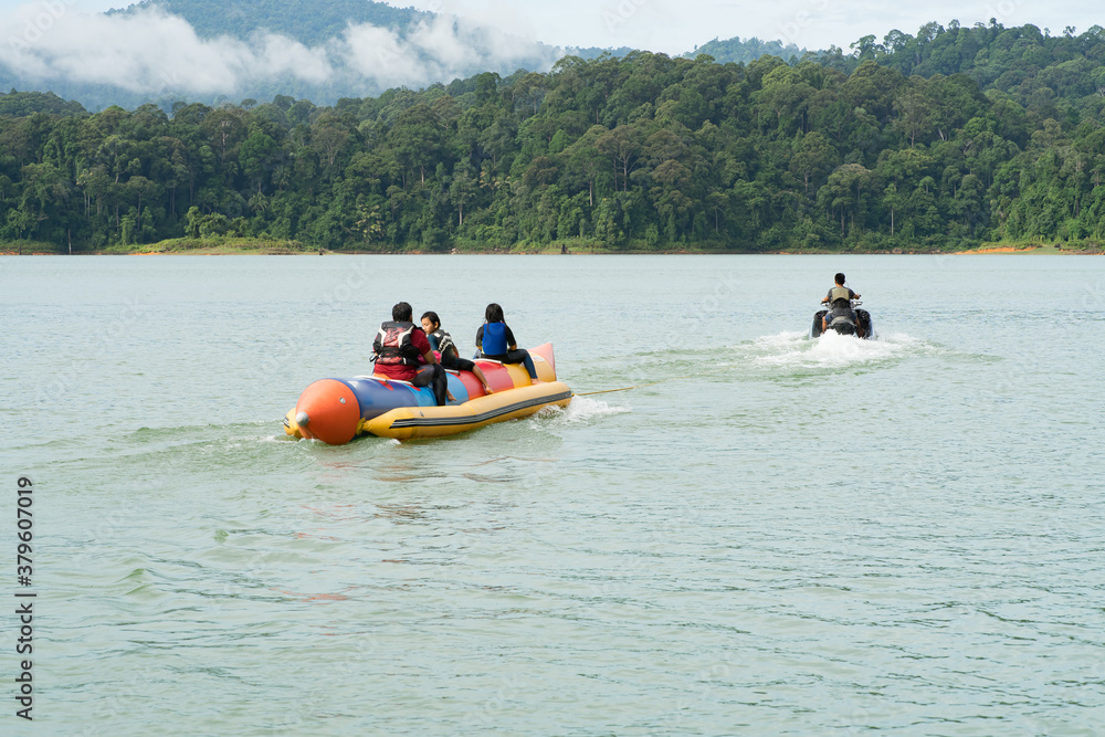 People enjoying water activities on banana boat at the Kenyir Lake, Terengganu, Malaysia.
