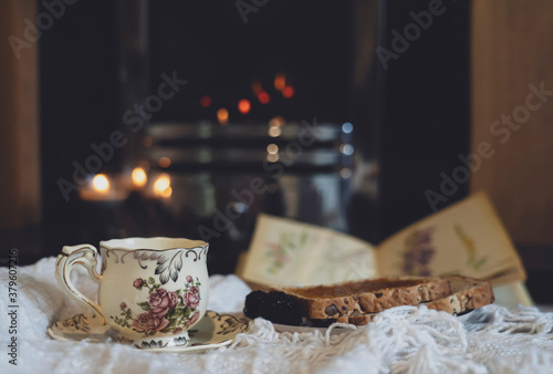 Hot coffee or cup of tea with steam and toast with blurry fireplace in drak room background, Scene cozy and relaxing for having breakfast in gloomy day on autumn or winter, English traditional