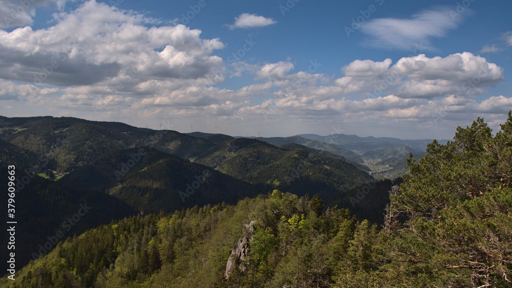 Beautiful view over hilly Black Forest and Gutach valley from Rappenfelsen near Hornberg, Baden-Wuerttemberg, Germany with wind power turbines in background on sunny day in late spring.