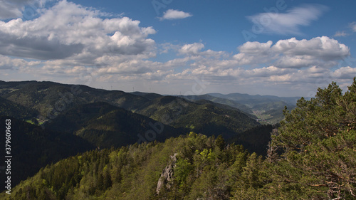 Beautiful view over hilly Black Forest and Gutach valley from Rappenfelsen near Hornberg, Baden-Wuerttemberg, Germany with wind power turbines in background on sunny day in late spring.