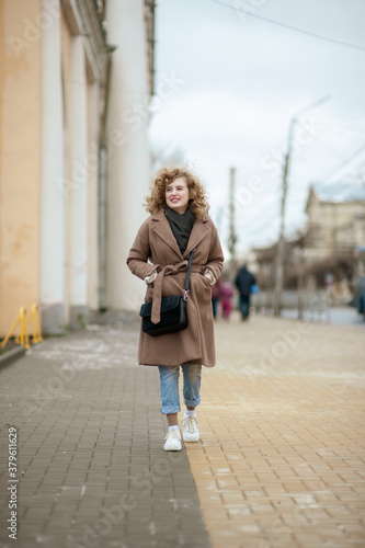 Portrait of a curly-haired young woman who walks the streets of the city © Kiryakova Anna