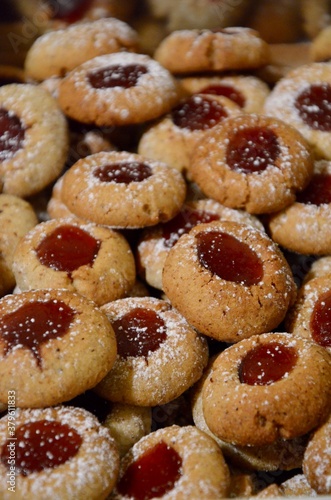 Traditional homemade German Christmas cookies Husarenkrapferl (Hussar donuts) or Engelsaugen (Eyes of an Angel), red currant jam filling, powdered sugar on top