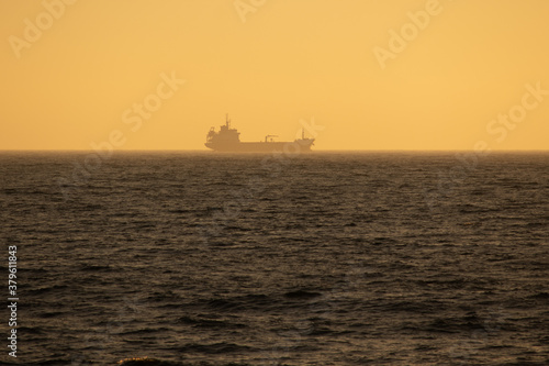 Large cargo ship sailing smoothly in the ocean during a wonderful sunset, Portugal © paulomachado_9