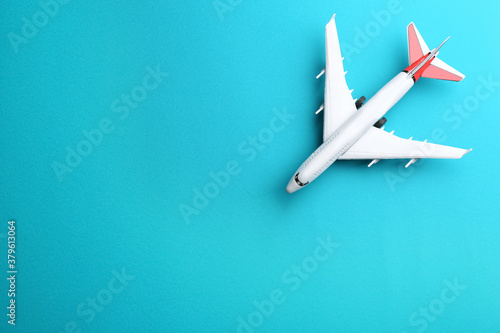 Toy airplane on light blue background, top view. Space for text