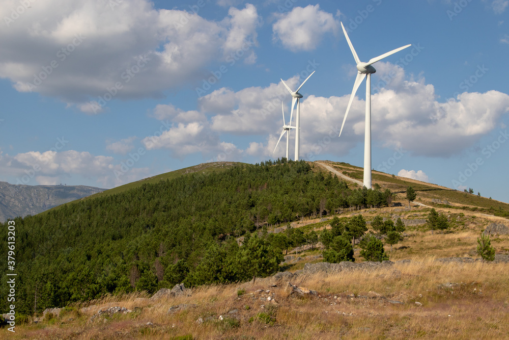 beautiful mountain landscape, with wind power towers on top of mountain, and under a beautiful blue sky, Serra da Estrela, Portugal beautiful mountain landscape, with wind power towers on top of mountain, and under a beautiful blue sky, Serra da Estrela, Portugal
