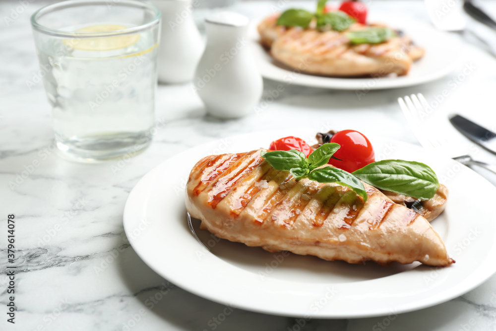 Tasty grilled chicken fillet with green basil and tomatoes on white marble table, closeup Tasty grilled chicken fillet with green basil and tomatoes on white marble table, closeup