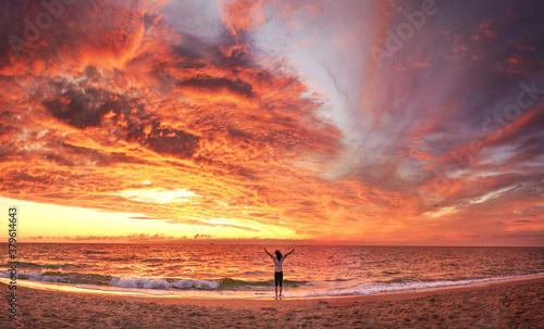 View of a happy woman on the sunset beach