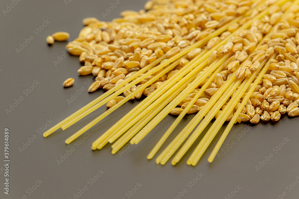 Macaroni products lie in grains of ripe Golden wheat. Close up. Soft focus Macaroni products lie in grains of ripe Golden wheat. Close up. Soft focus