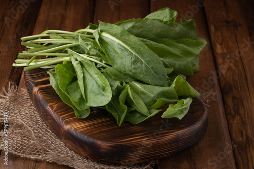 Eco vegetables - fresh green spinach on wooden background, vegan food