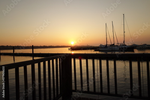 Abenddammerung und Sonnenuntergang durch Geländer Fotografiert am Jachthafen mit Jachten im Hintergrund