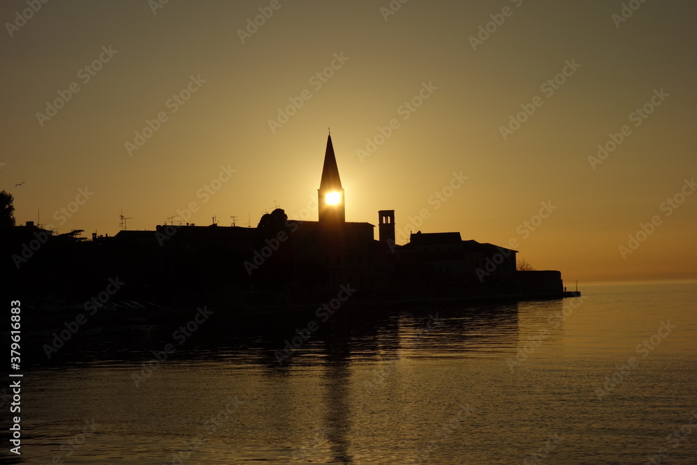 Sonnenuntergang bei Kroatischen Fischerdorf. Die Sonne ist direkt im Kirchturm