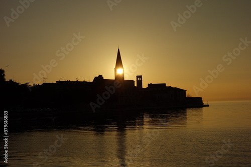 Sonnenuntergang bei Kroatischen Fischerdorf. Die Sonne ist direkt im Kirchturm